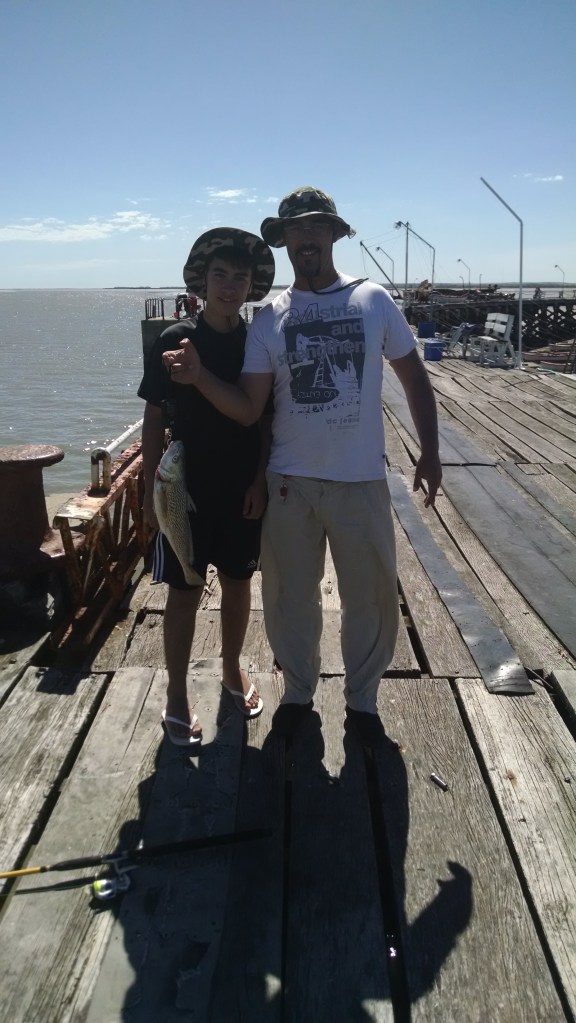 Rodrigo y su hijo, con la corvina 